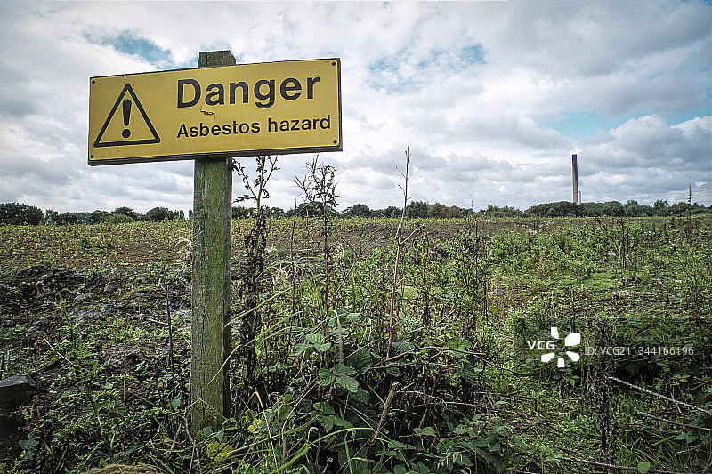 在用于掩埋最近拆除的发电站的石棉废料的土地旁边的警告标志图片素材