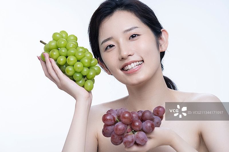 美丽的女孩拿着葡萄图片素材