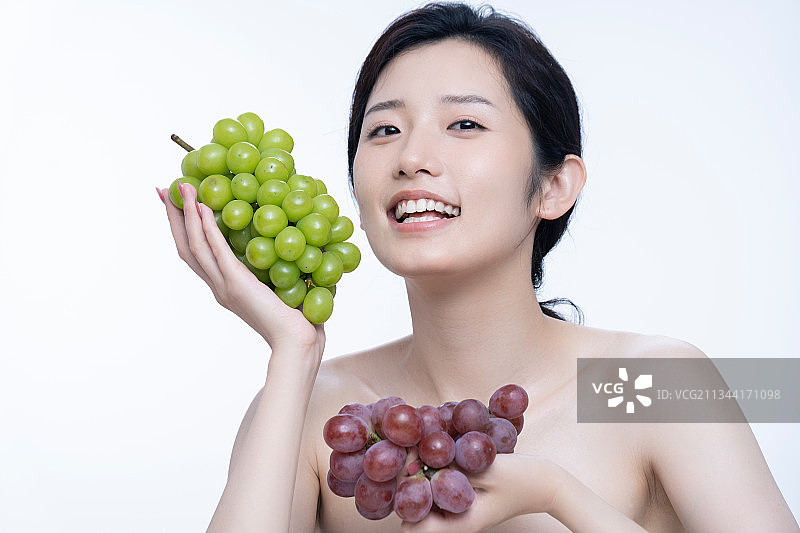 美丽的女孩拿着葡萄图片素材