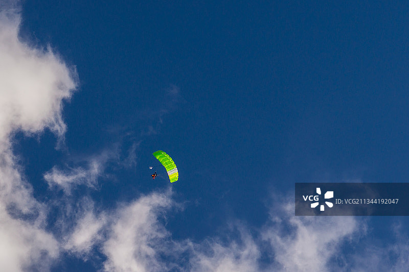 低角度视角的人滑翔伞对蓝色的天空图片素材