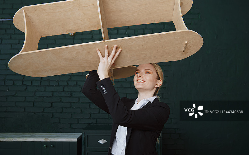 在办公室玩大型飞机模型的年轻女商人图片素材