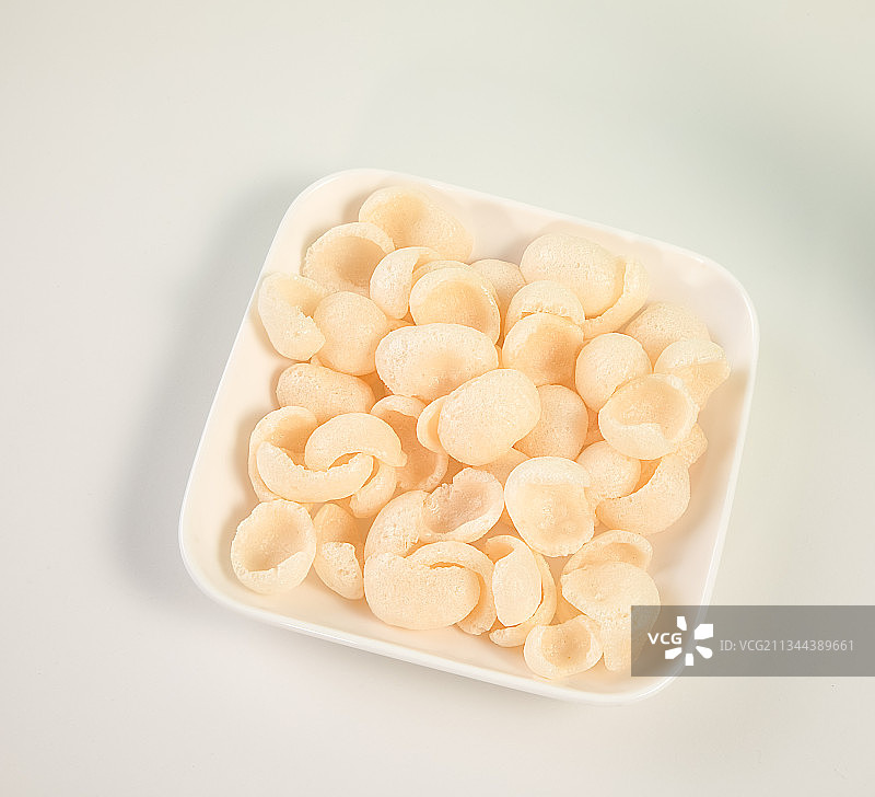 放在白色陶瓷盘子里的虾片图片素材