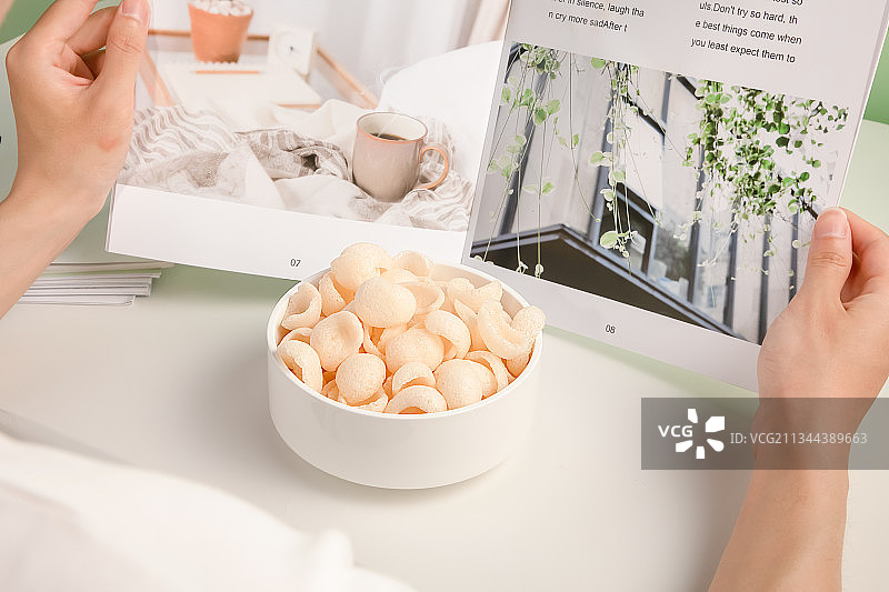 一边阅读一边吃美味的虾片图片素材