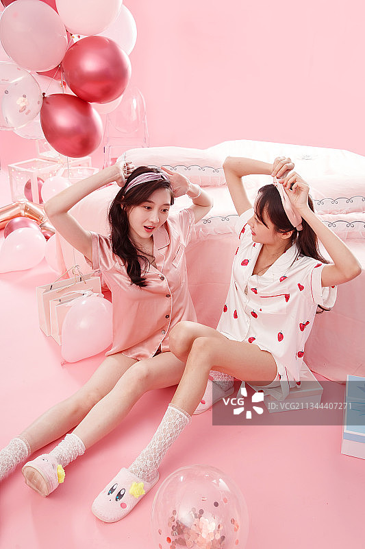 卧室内快乐玩耍的年轻闺蜜图片素材