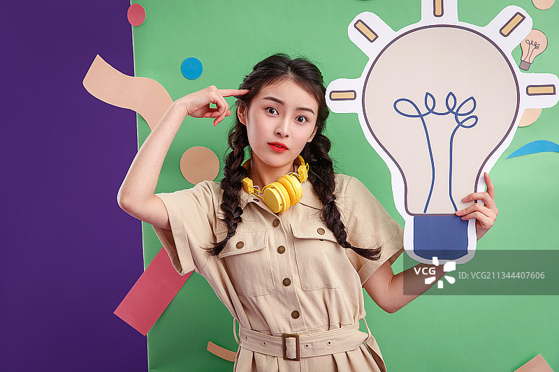 拿着灯泡图标的年轻女孩图片素材