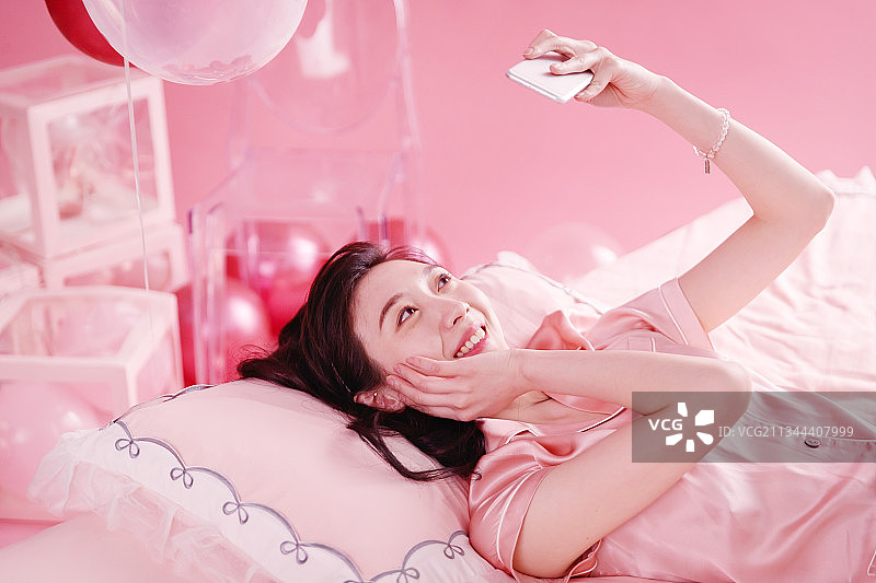 躺在床上自拍的年轻女孩图片素材