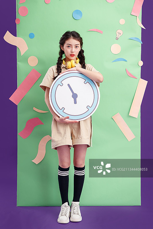 拿着闹钟的年轻女孩图片素材