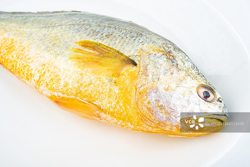 菜碟上一条新鲜黄花鱼图片素材