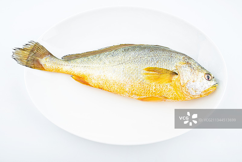 菜碟上一条新鲜黄花鱼图片素材