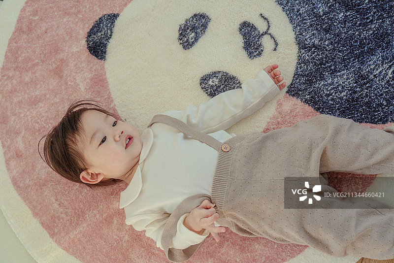 小男孩躺在地板上与熊猫宝宝作伴图片素材