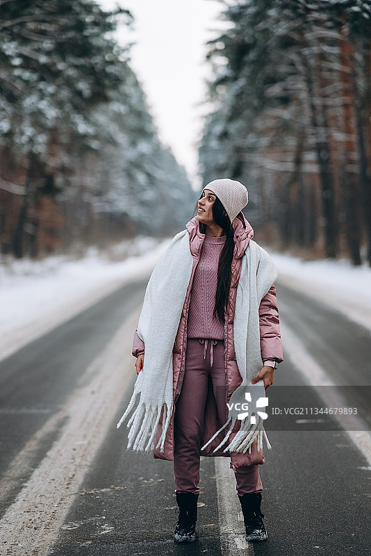 年轻女人走在冬日的道路上图片素材