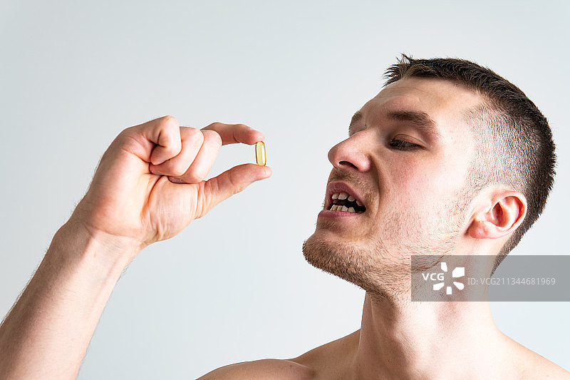 男子食用鱼油补充剂图片素材