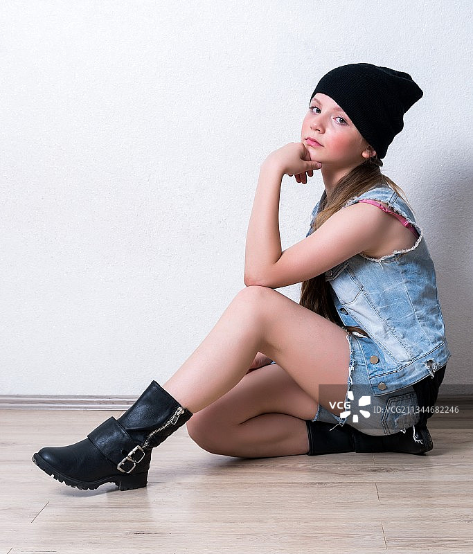 靠墙坐着的女孩侧视图图片素材