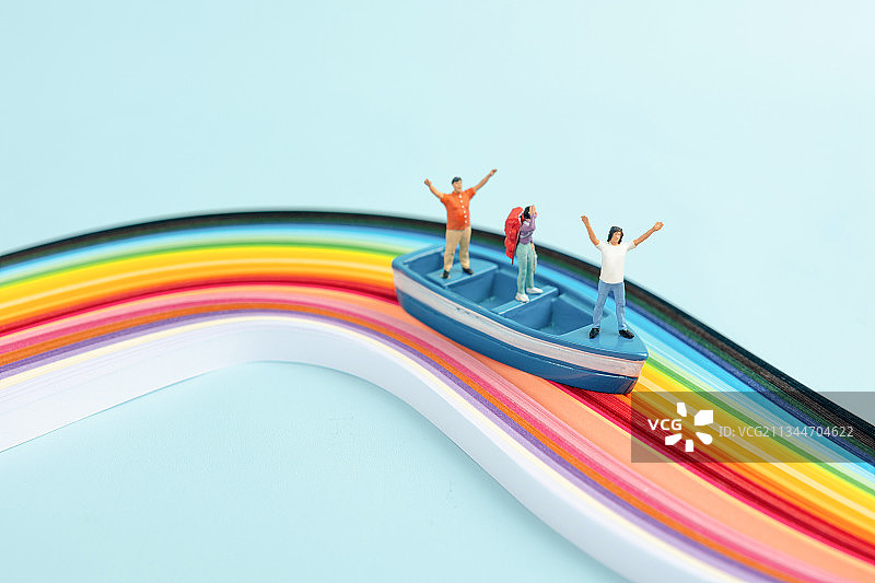 微缩景观夏天在彩虹纸上划船旅行的青年图片素材