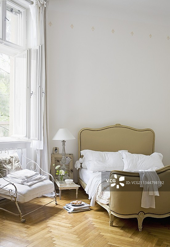 法式科贝耶床和铁扶手椅，位于人字形拼花地板的卧室图片素材