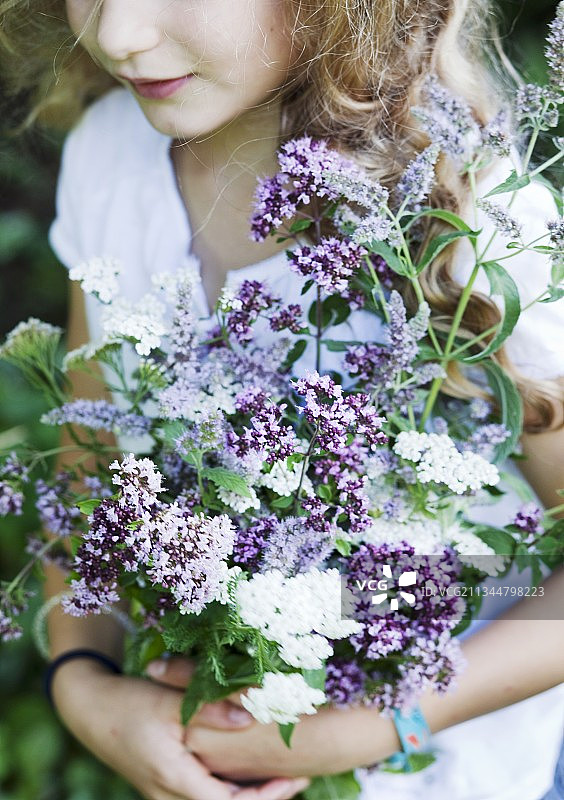 女孩在花园里拿着一束香草图片素材