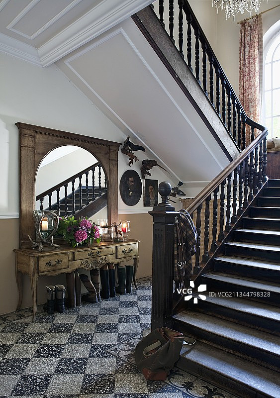 庄园房屋的楼梯间，水磨石地面和带有木制栏杆的楼梯图片素材