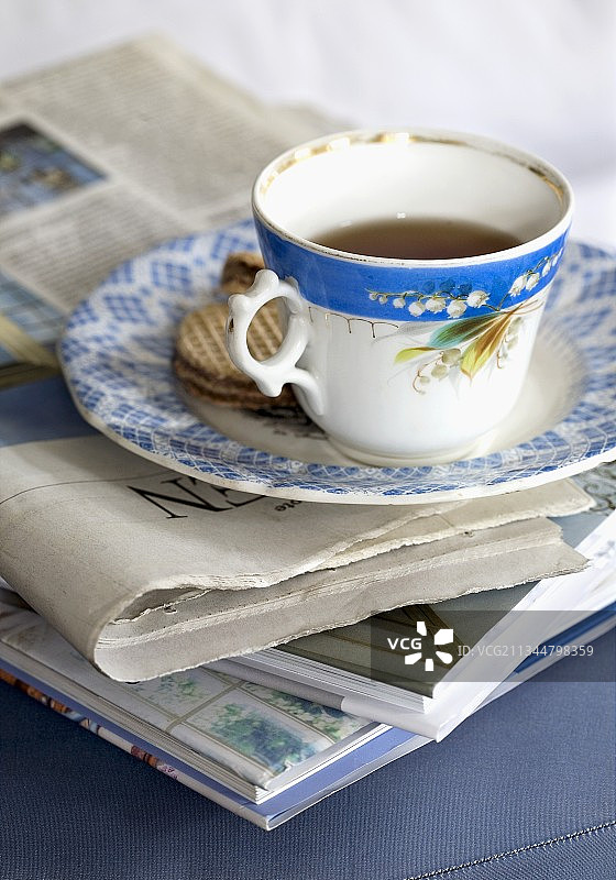 复古茶杯与报纸上的饼干图片素材