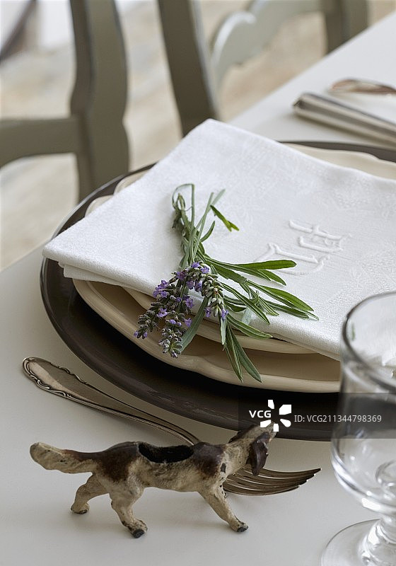 桌子上亚麻餐巾旁薰衣草小狗装饰品图片素材
