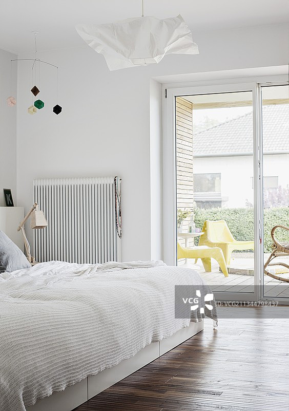 简约卧室：白色床罩双人床，可欣赏景色的露台门图片素材