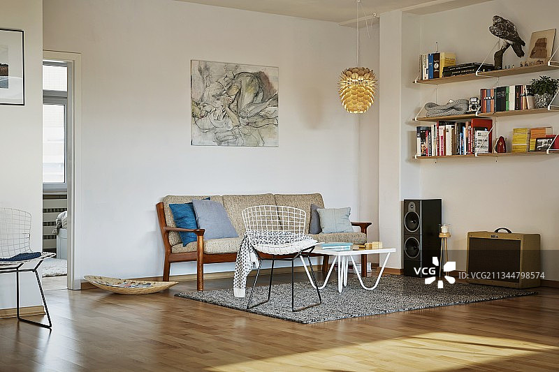 极简客厅，休息区配有经典椅子和五十年代风格的地毯沙发图片素材