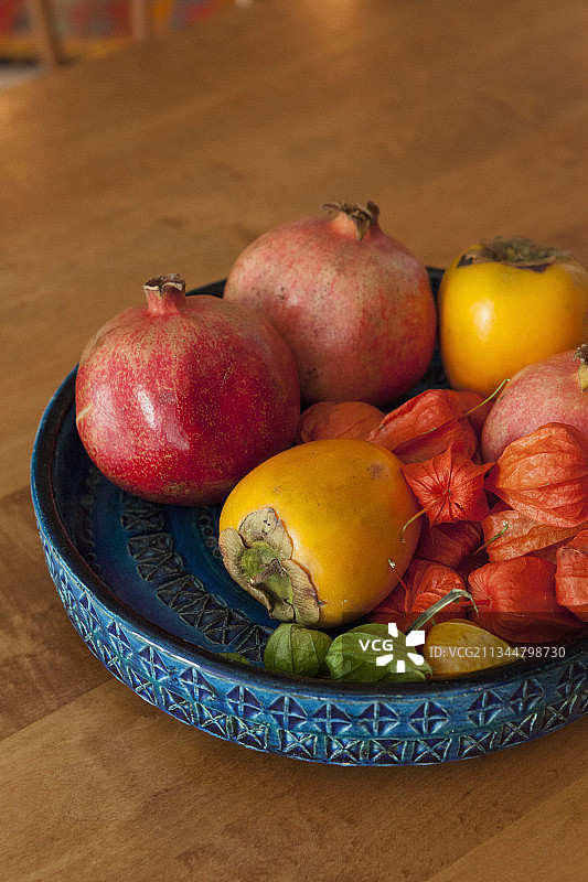 盛放红色异域水果的蓝色纹理碗图片素材