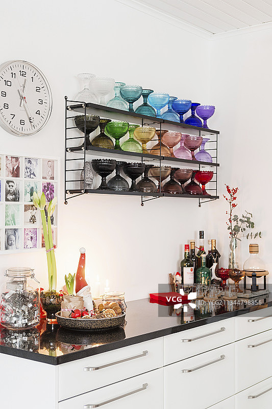 厨房底柜上、彩色玻璃高脚杯架下的圣诞装饰图片素材