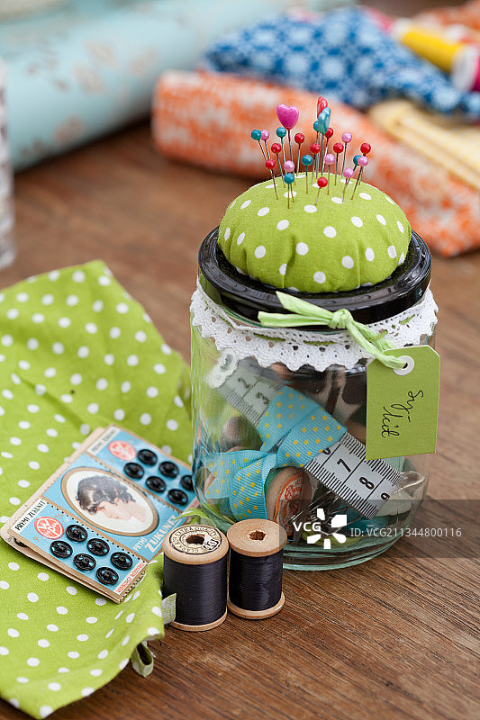 带针垫盖的螺旋盖罐子里的缝纫用具图片素材