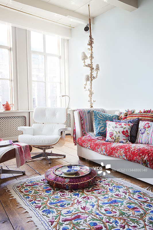 色彩缤纷的配饰和经典伊姆斯躺椅，位于历史建筑的客厅内图片素材