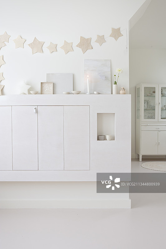 星形花环下的白色餐具柜图片素材