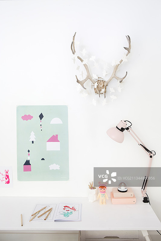 白色书桌上方的狩猎奖杯和纸质装饰品图片素材