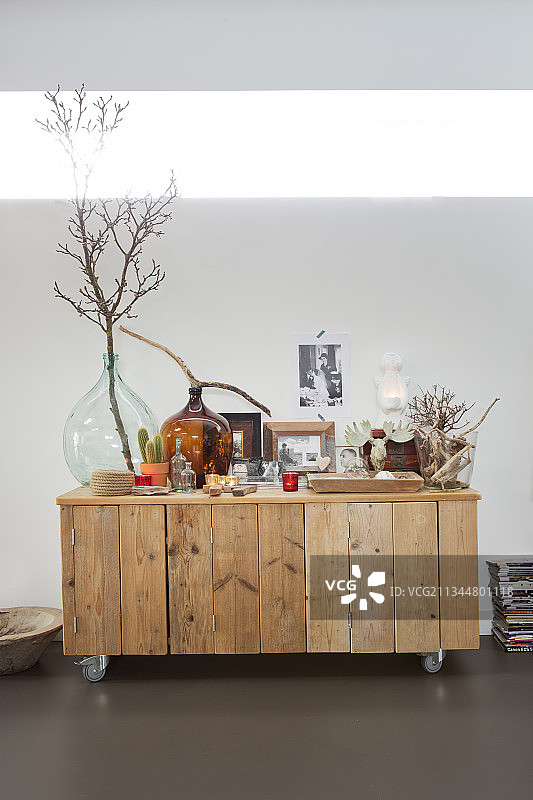 用再生木材制成的橱柜上的坛子、照片和天然装饰材料图片素材