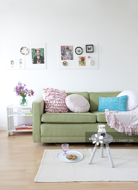 绿色沙发上的浪漫枕头，背景是两块情绪板图片素材