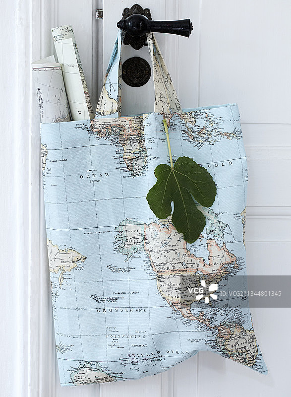 带有世界地图图案和卷起地图的织物袋图片素材