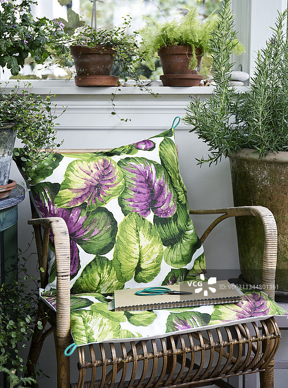 藤椅上带有时髦图案的靠垫图片素材