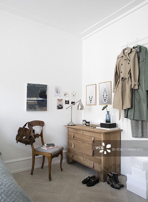 门旁边的风衣和带有皮革带抽屉的柜子图片素材