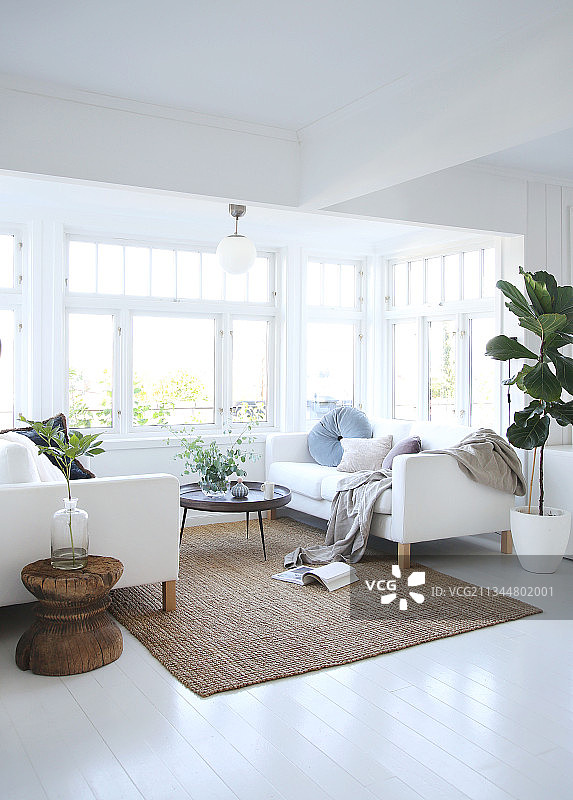 开放式客厅窗前的白色沙发和圆形桌子图片素材