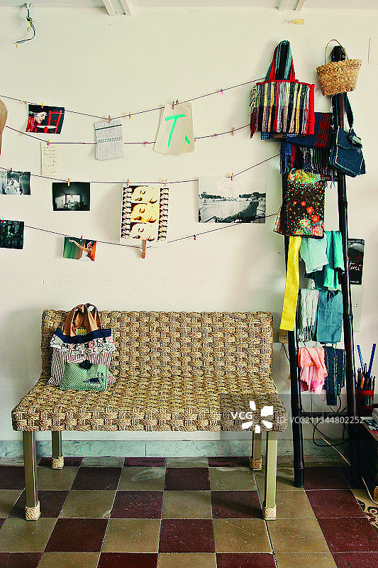 走廊里带有棋盘地板和梯子置物架的编织长凳图片素材