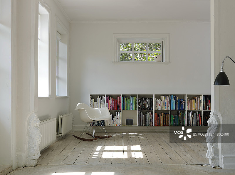 通往客厅的通道中的雕塑，配有摇椅和书架图片素材