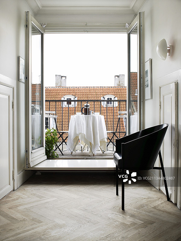 开放式阳台门前的黑色设计师椅图片素材