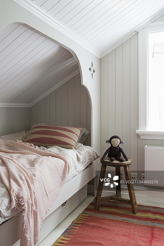 猴子玩偶、矮墙边的床图片素材