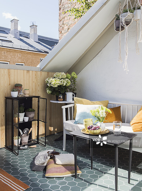阳光下的屋顶露台休息区，配有蜂窝瓷砖、长椅和桌子图片素材