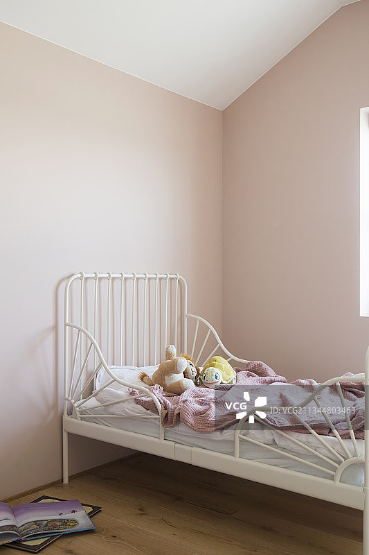 粉色墙壁儿童卧室中的白色床图片素材