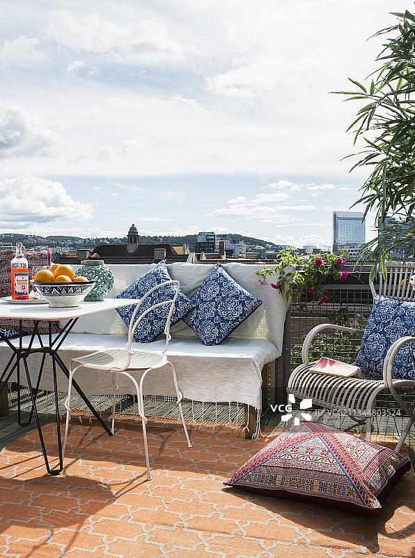 屋顶露台上的桌子、长椅、椅子和坐垫图片素材