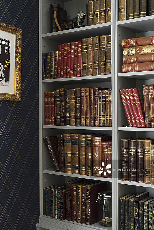 深蓝色菱形壁纸旁书架上的旧书图片素材
