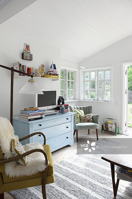 明亮复古风客厅中的淡蓝色抽屉柜图片素材