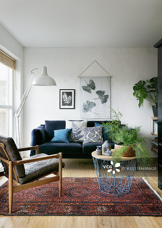 客厅蓝色丝绒沙发前的金属线篮底座咖啡桌图片素材