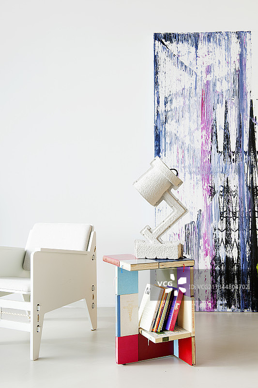 扶手椅和彩色边桌，旁边是抽象画图片素材