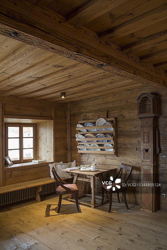 乡村农舍客厅餐桌和置物架旁的老式落地钟图片素材