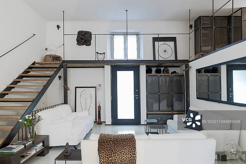 工业风阁楼公寓中的白色沙发和通往画廊的楼梯图片素材